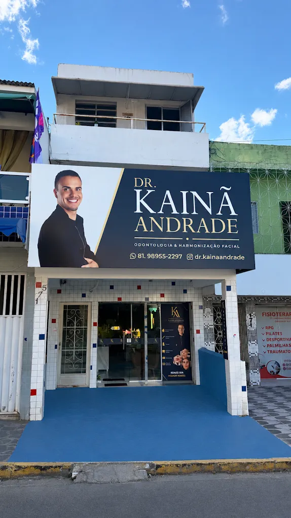 Fachada da clínica com a placa azul-marinho e dourada do Dr. Kainã Andrade